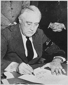 Franklin D. Roosevelt signs the declaration of war with Japan. 