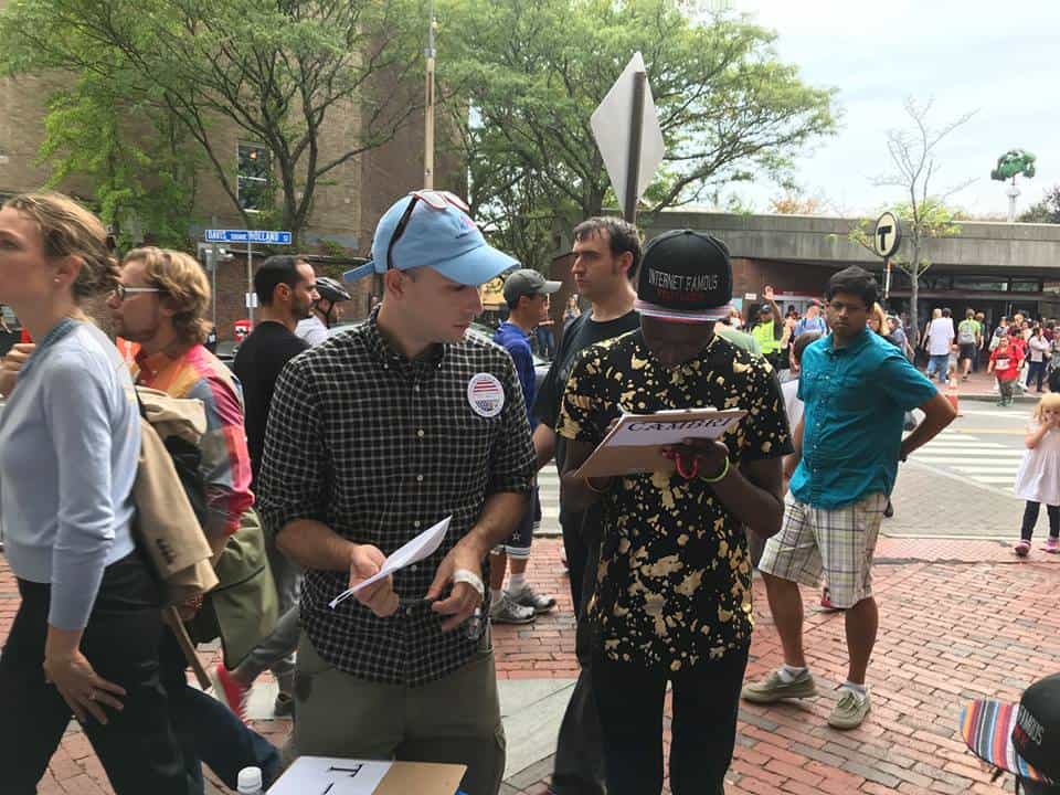 Man soliciting signatures in crowd of people